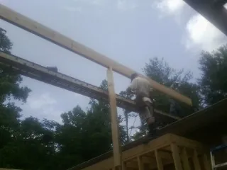 Carpenter setting a ridge beam over a new addition frame — Ice Dam Removal by Roofing Brothers in Larwill
