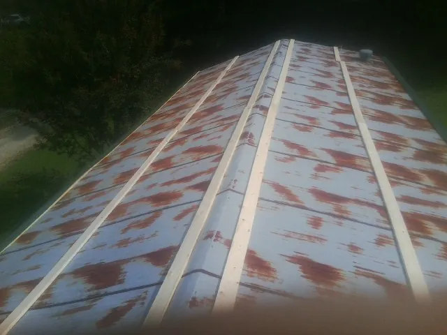 Rusted metal roof panels with new wood purlins before replacement — Storm Damage Roof Repair in Larwill by Roofing Brothers